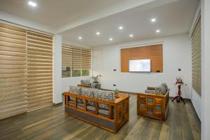 vestíbulo con persianas de madera, mesa y sillas en Anu - The Breeze of Heaven en Kandy