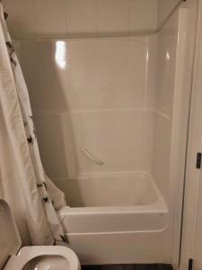 a bathroom with a white tub and a toilet at 1 Bedroom with Balcony in Calgary