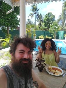 a man and a woman sitting at a table with a plate of food at Kingz and Queenz - Negombo in Negombo