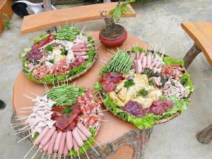 stół z trzema talerzami jedzenia. w obiekcie Wind Hill Homestay Hà Giang 