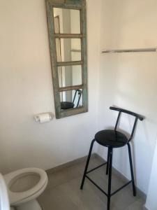 a bathroom with a stool and a mirror and a toilet at Khomas Hochland Chalet in Prospect +3 photos