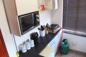 a kitchen with a counter top with a microwave at Khomas Hochland Chalet in Prospect