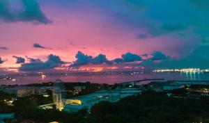 マニラにあるRQ Cozy One Bedroom Condo, Coast Residences Pasayの夕日を眺めながらの夜の街並み