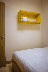 マニラにあるRQ Cozy One Bedroom Condo, Coast Residences Pasayのベッド1台と壁に棚が備わる客室です。 +21枚の写真