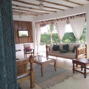 a living room with a couch and a table at Shira house in Watamu