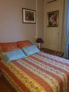 a bedroom with a large bed with blue pillows at le cardinal in Culoz