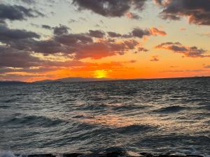 a sunset over the ocean with the sun setting at GuestHouse紫雲 -SHIUN- in Toyohama +55 photos