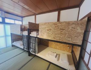 Habitación con 3 literas en una habitación en awa guesthouse, en Tateyama