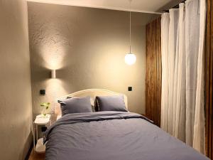 a bedroom with a bed with blue blankets and pillows at Grey studio in Maardu in Maardu