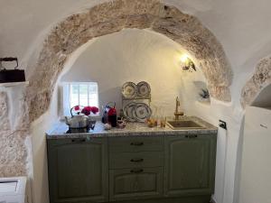 cocina con armario verde y fregadero en Anglica's Suite, en San Michele Salentino