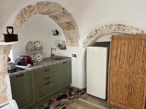 cocina con armarios verdes y nevera blanca en Anglica's Suite, en San Michele Salentino