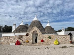 un pequeño edificio de piedra con techo con fruta delante en Anglica's Suite, en San Michele Salentino