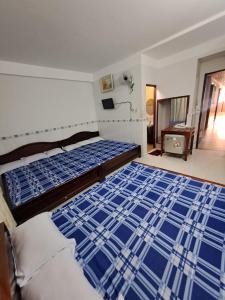 1 dormitorio con 2 camas con sábanas azules y blancas en NHÀ NGHỈ NAM PHƯƠNG en Ha Tien