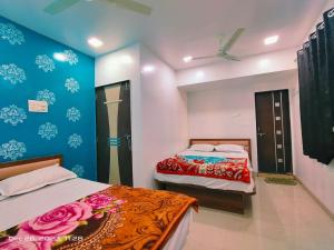 a bedroom with two beds and a ceiling fan at Amrit Guest House Pune in Pune