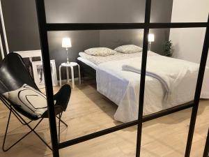 een slaapkamer met een bed en een stoel erin bij Kaunis moderni tilava asunto in Rauma
