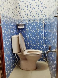 La salle de bains est pourvue de toilettes avec des points de polka bleus et blancs. dans l'établissement Hotel Short Time Stay, à Dhaka