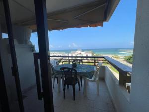 a table and chairs on a balcony with a view of the ocean at Solemar resort, Kaslik, all Fees are included Generator, electricity, wifi,etc in Al Kaslīk