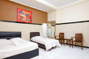 a bedroom with two beds and a table and chairs at Dya Hotel Boyolali in Boyolali