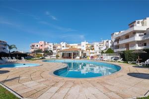 a swimming pool in front of some buildings at Apartamento Santos in Tavira