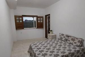 1 dormitorio con cama y ventana en Casa Amarela em Camamu - BA, en Camamu
