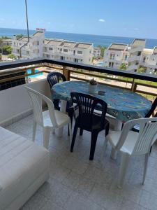 patio con mesa y sillas en el balcón en Chalet en urbanisazion de Solemar, piscinas, tennis, futbol, Balon cesto, en Al Kaslīk