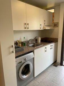 a kitchen with a washing machine and a sink at Chalet en urbanisazion de Solemar, piscinas, tennis, futbol, Balon cesto in Al Kaslīk