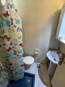 łazienka z toaletą i zasłoną prysznicową z motylami w obiekcie Chalet en urbanisazion de Solemar, piscinas, tennis, futbol, Balon cesto w mieście Al Kaslīk