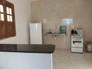 eine Küche mit einem weißen Kühlschrank und einer Spüle in der Unterkunft Casa Amarela em Camamu - BA in Camamu
