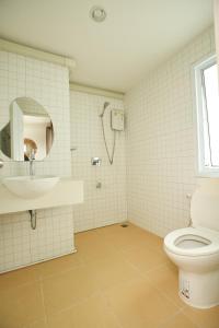 La salle de bains est pourvue de toilettes, d'un lavabo et d'un miroir. dans l'établissement Imm Paknham, à Ban Hin Sam Kon