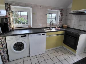 a kitchen with a washing machine and a sink at Nörderland in Norden