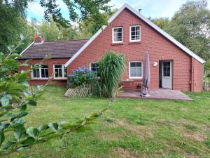 a red brick house with a grass yard at Nörderland in Norden