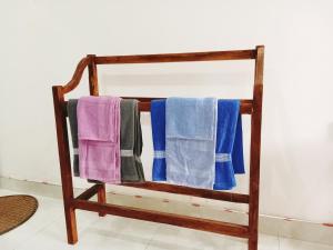 un toallero de madera con 4 toallas. en New Summer Vacation, en Hikkaduwa