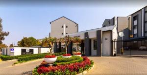 a building with a bunch of flowers in front of it at Classy 2 bedroom in Halfway Gardens in Midrand