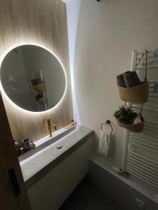 a bathroom with a round mirror and a sink at Apartmán TOMI in Brezno