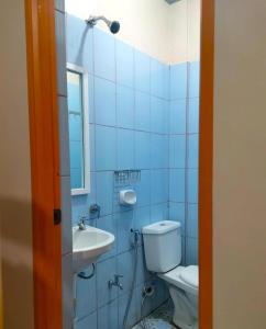La salle de bains est pourvue de carrelage bleu, de toilettes et d'un lavabo. dans l'établissement Madie's Apartelle near EK & Laguna Technopark, à Santa Rosa
