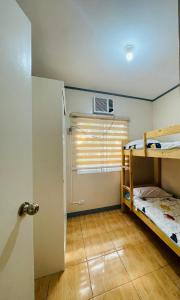 Cette chambre comprend 2 lits superposés et une fenêtre. dans l'établissement Madie's Apartelle near EK & Laguna Technopark, à Santa Rosa