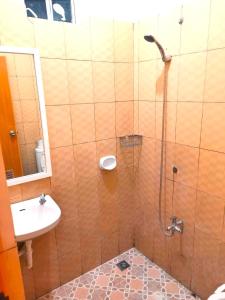 La salle de bains est pourvue d'une douche et d'un lavabo. dans l'établissement Madie's Apartelle near EK & Laguna Technopark, à Santa Rosa