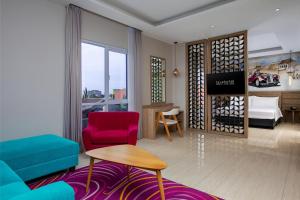 a living room with a couch and a bed at favehotel Sidoarjo in Sidoarjo