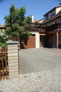 ein Haus mit einem Zaun und einer gemauerten Auffahrt in der Unterkunft Weimar Ferienwohnung am Goethepark in Weimar