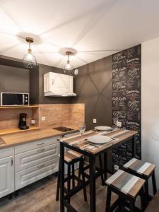 cocina con mesa con sillas y pizarra en L'Atelier- appartement cosy avec cour - centre, en Bourgoin