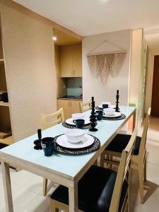 uma mesa de jantar com cadeiras e uma mesa branca com pratos em Kuta View Apartment with 2 BR in Kuta Bali em Kuta