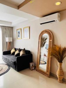 uma sala de estar com um sofá preto e um espelho em Kuta View Apartment with 2 BR in Kuta Bali em Kuta