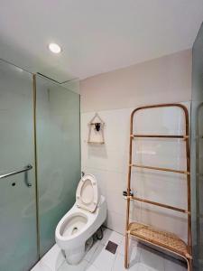 uma casa de banho com um WC e uma cabina de duche em vidro. em Kuta View Apartment with 2 BR in Kuta Bali em Kuta