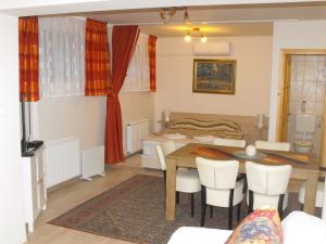 a living room with a table and a dining room at Ezüsthíd Apartman in Balatongyörök