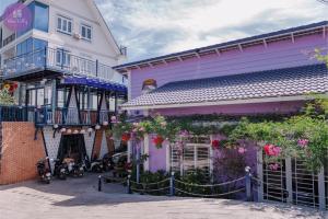 a purple building with flowers on the side of it at Wine Valley Homestay Dalat in Xuan An