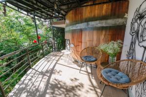 a balcony with chairs and a painting on the wall at Wine Valley Homestay Dalat in Xuan An