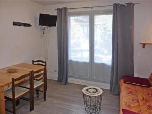 ein Wohnzimmer mit einem Tisch und einem Fenster in der Unterkunft Résidence ORR DES FORETS - Studio pour 4 Personnes 794 in Les Orres