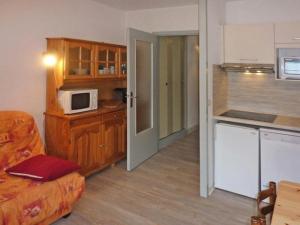 ein Wohnzimmer mit einer Küche und einer Mikrowelle in der Unterkunft Résidence ORR DES FORETS - Studio pour 4 Personnes 794 in Les Orres