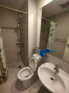 a bathroom with a toilet and a sink at SM Bicutan Condominium in Manila