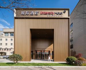 上海IntercityHotel Shanghai Hongqiao Airport - Free Minibar for First Night的妇女走进办公大楼的入口